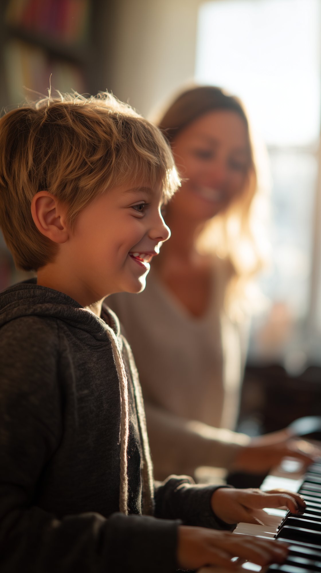 Young boy smiling while playing piano during an in-home lesson in East Cobb, GA